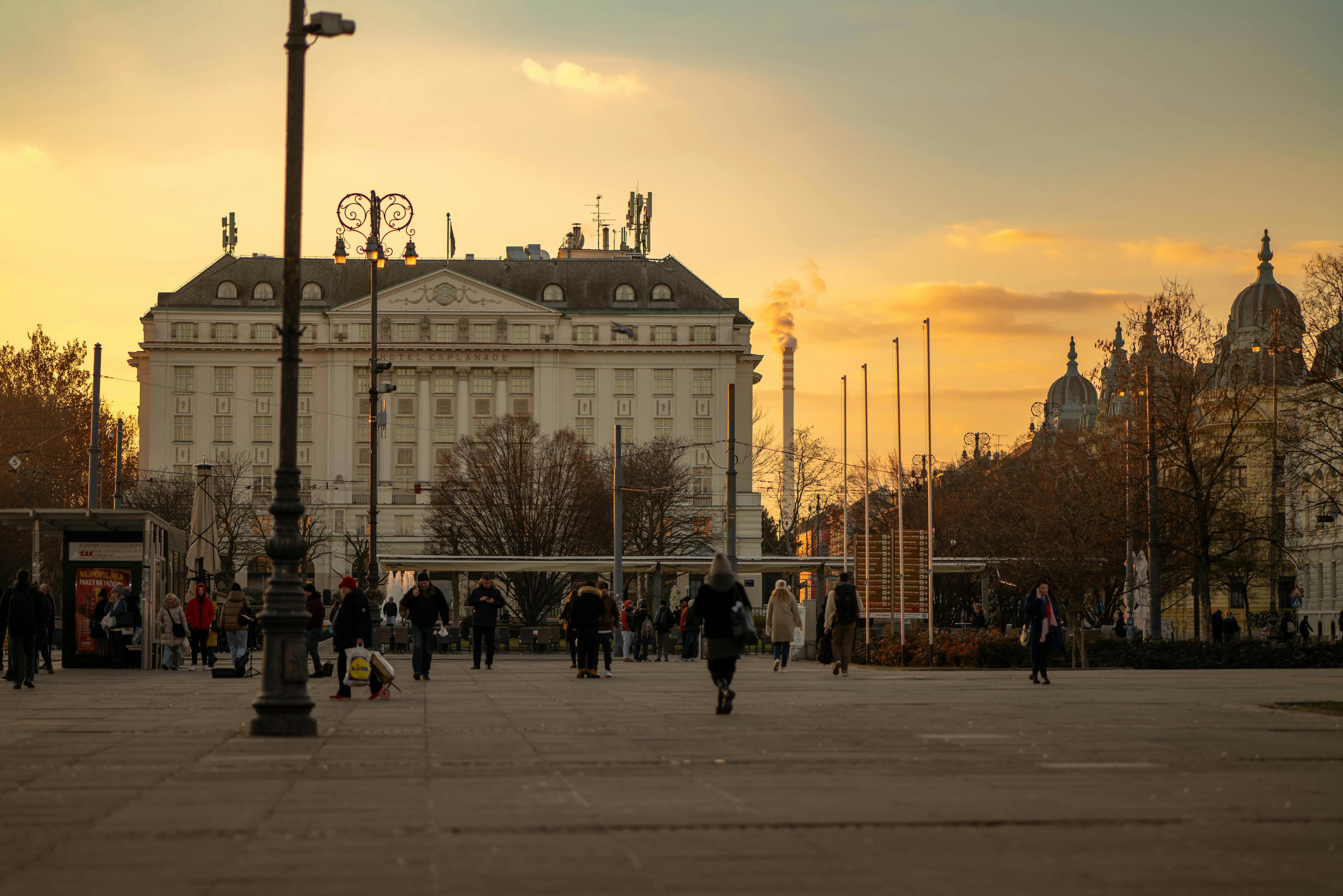 Capture of Zagreb's skyline at sunset, featuring a prominent historic building and city life