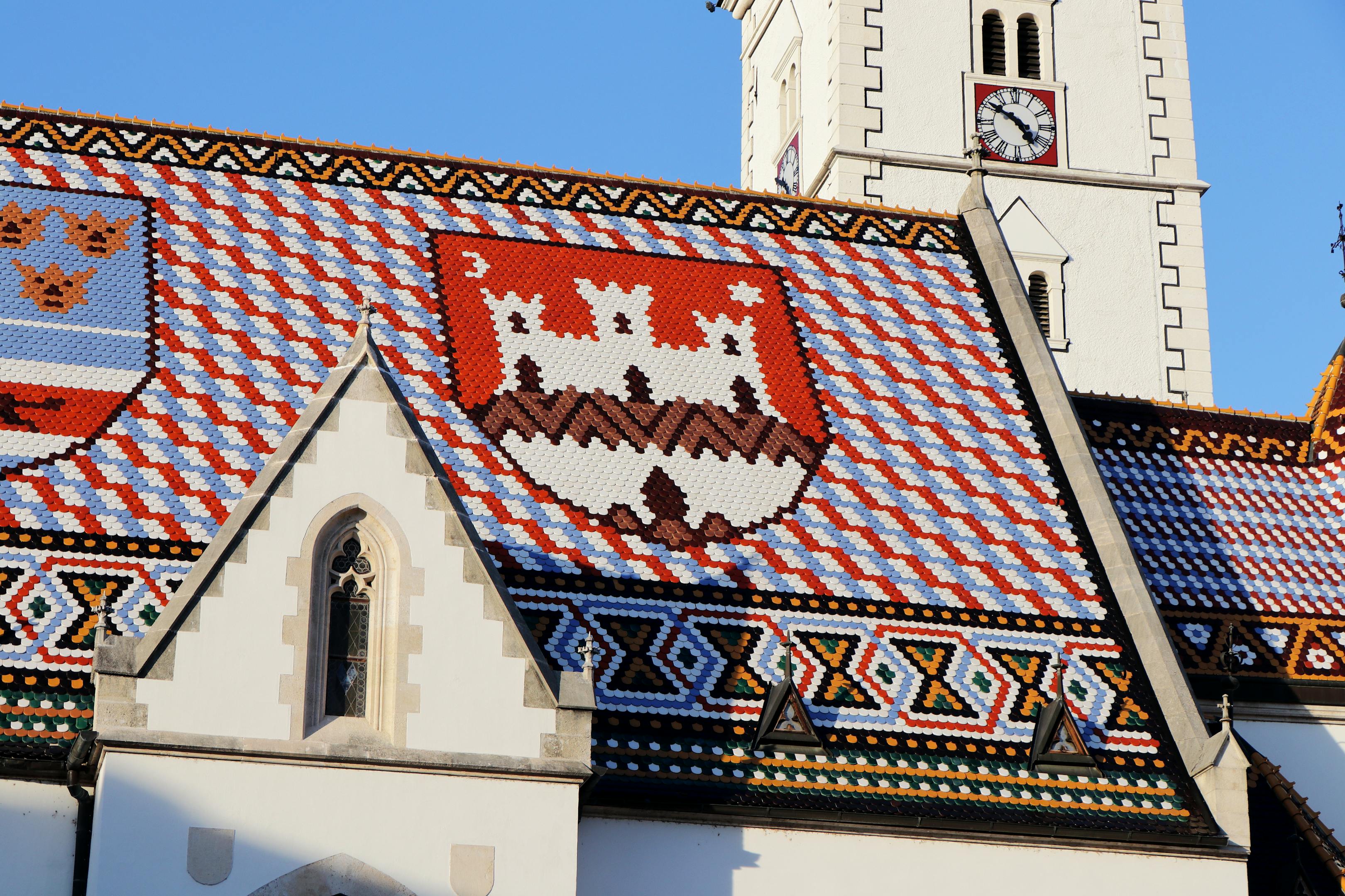 Colorful tiled roof of St. Mark's Church in Zagreb, Croatia, showcasing intricate historical architecture under a sunny sky